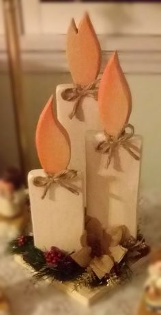 three candles with bows on them sitting on a table