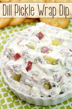 a white bowl filled with fruit and crackers on top of a green table cloth