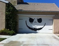 a garage with a smiley face painted on the front door and side of the house