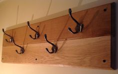 three hooks are attached to a wooden coat rack