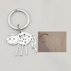 a keychain with a drawing of a horse on it's face and the bottom part of its body