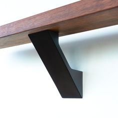 a close up of a wooden shelf with metal brackets