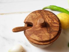 a small wooden box sitting on top of a counter next to garlic and lemons