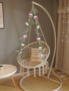 a white hanging chair with pink flowers on it