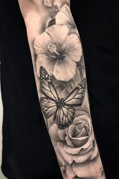 a woman's arm with flowers and a butterfly on it