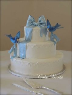 a three tiered cake with blue bows on top