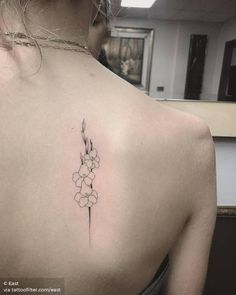 a woman's back with a flower tattoo on it