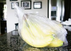 a plastic bag filled with food sitting on top of a counter next to an oven