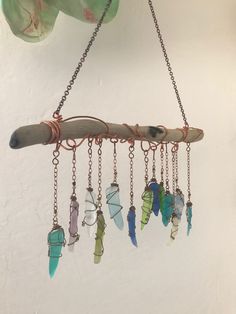 a wind chime hanging from a chain with several different colored beads attached to it