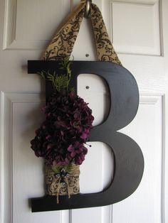 the letter b is decorated with purple flowers and burlocked in burlocks