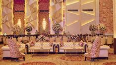 an elaborately decorated banquet hall with chandeliers and floral arrangements on the walls