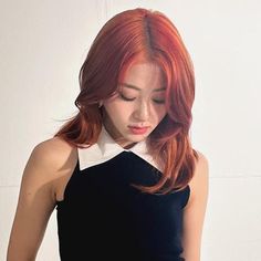 a woman with red hair wearing a black and white dress