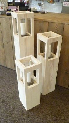 three wooden containers with candles in them sitting on the floor next to a counter top