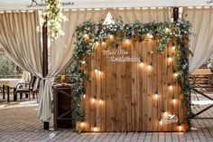 the entrance to a restaurant decorated with greenery and fairy lights for an outdoor wedding