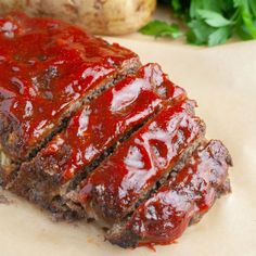 the meatloaf is covered with ketchup and sauce next to some vegetables