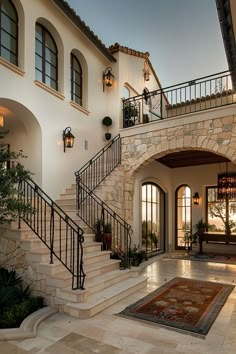 the entrance to a large home with stone steps and wrought iron railings on both sides