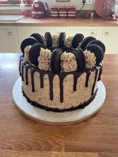 a cake with oreo cookies and cream frosting on it sitting on top of a wooden table