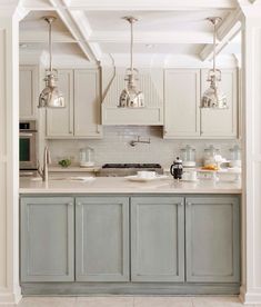 a kitchen with white cabinets and gray counter tops