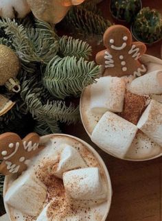 two cups filled with hot chocolate and marshmallows on top of a table