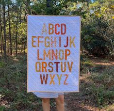 a woman holding up a sign with letters on it