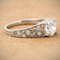 an antique style diamond engagement ring with filigrees