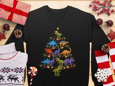 Celebrate the holidays with our fun Christmas Dinosaur Sweatshirt featuring a unique Dino Christmas Tree design! Perfect for adding some holiday cheer, this funny holiday sweatshirt is available in both kid and adult sizes, making it the ideal festive apparel for the whole family. The playful and vibrant dinosaurs are sure to bring smiles and spread the holiday spirit. Gift it to a dinosaur lover or wear it to your next holiday gathering for guaranteed festive fun! Dino Christmas, Dinosaur Sweatshirt, Christmas Tree Top, Christmas Dinosaur, Christmas Tree Tops, Tree Top, Funny Holiday, Xmas Sweater, Holiday Sweatshirt