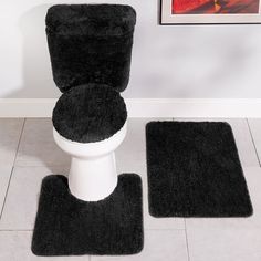 a toilet with two rugs on the floor next to it and a framed photo