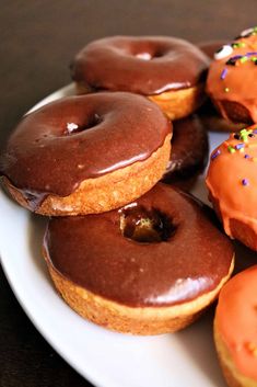 a white plate topped with donuts covered in chocolate frosting