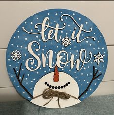 a sign that says let it snow with a snowman on top and the words, let it snow