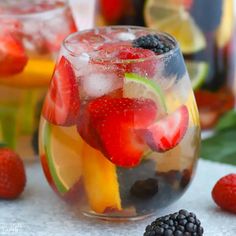 a pitcher and two glasses filled with fruit punch on a table next to each other