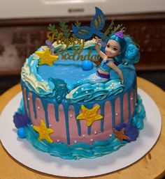 there is a birthday cake with a little mermaid on top and stars around the edges