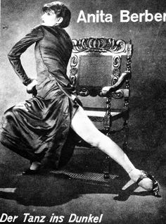 an old fashion photo of a woman sitting on a chair with her legs crossed in the air