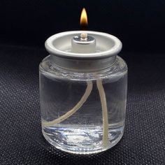 a small glass jar with a lit candle inside