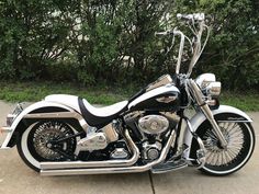 a black and white motorcycle parked in front of some trees