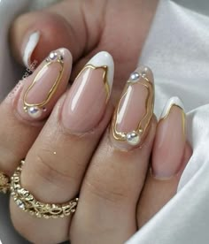 a woman's hand with some gold and white nails