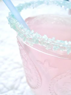 a pink drink sitting on top of a table next to a toothbrush in a cup