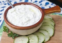 cucumber dip in a wooden bowl with sliced cucumbers on the side