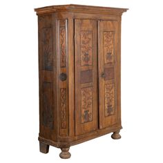 an old wooden armoire with carvings on the front and side panels, sitting against a white background