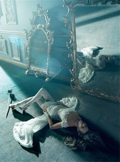 a woman laying on the floor in front of a mirror