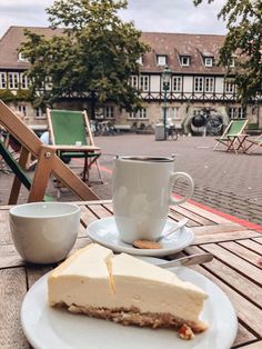 a slice of cheesecake on a plate next to a cup of coffee