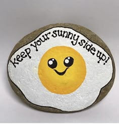 a rock with an egg painted on it that says keep your sunny side up,