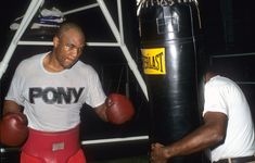 two men standing next to each other near a punching bag