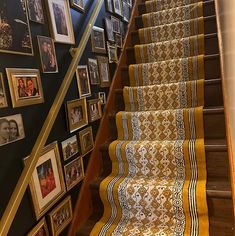 stairs with pictures on the wall and carpeted stair treads in front of them