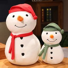 two snowmen standing next to each other on a table