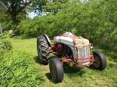 an old tractor is parked in the grass