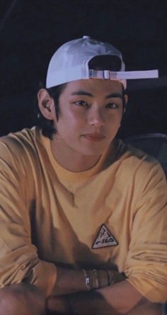 a young man wearing a white hat and yellow shirt