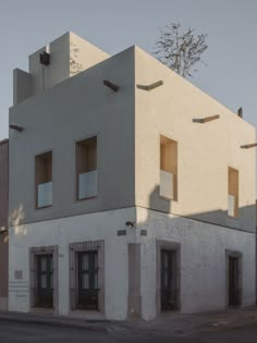 the building is white and has three windows on each side, along with two balconies