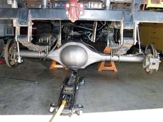 the front end of a vehicle with wheels and axles on it's stand