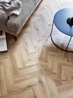 a coffee table sitting on top of a wooden floor next to a couch and book