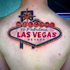 the back of a woman's neck with a welcome to fabulous las vegas tattoo